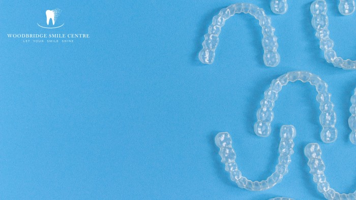 Multiple Invisalign aligners on a blue background