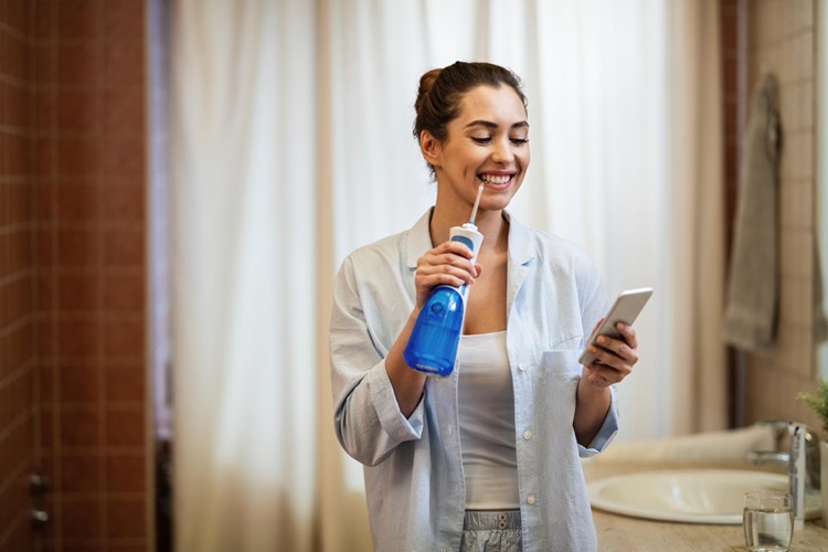 a happy woman using Water Flosser 